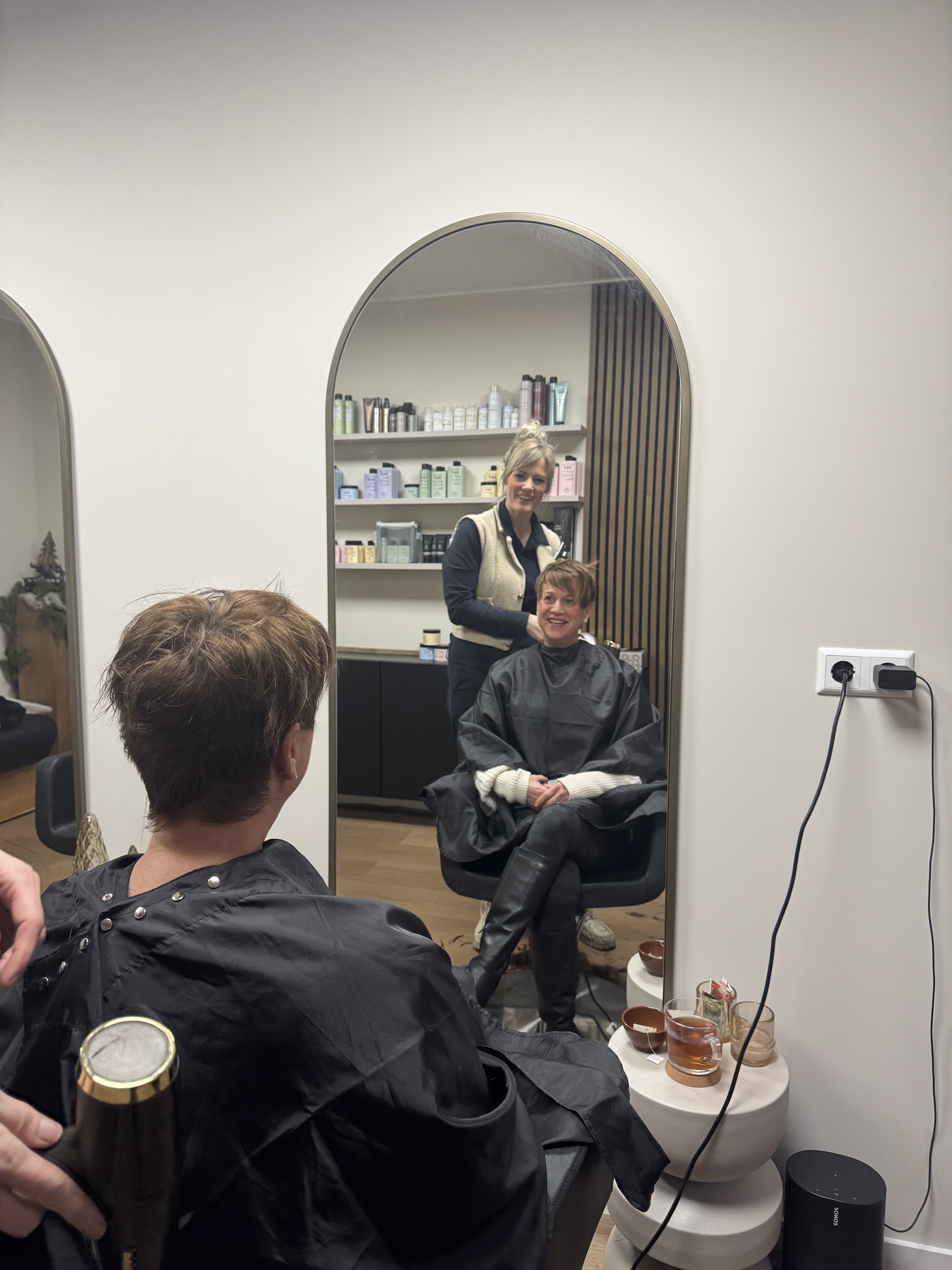 Wendy aan het werk, gezien in de boogspiegel van haar salon